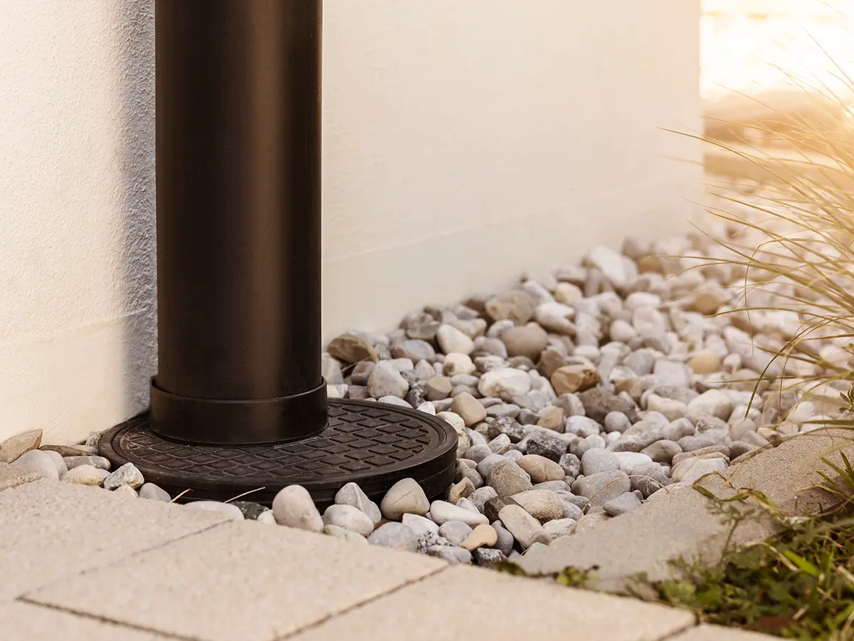 Drainage system near home with downspout and gravel