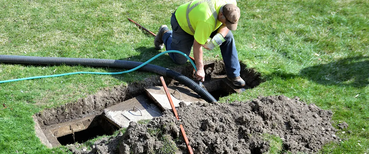 A workman installing a backyard septic tank