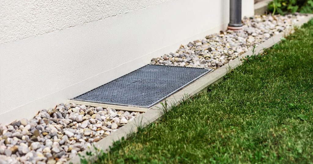 Foundation drainage system with metal grate and gravel border for basement waterproofing and water diversion