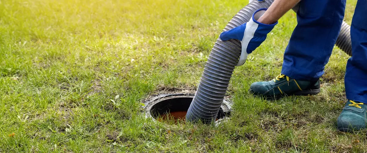 man pumping out house septic tank. drain and sewage cleaning service